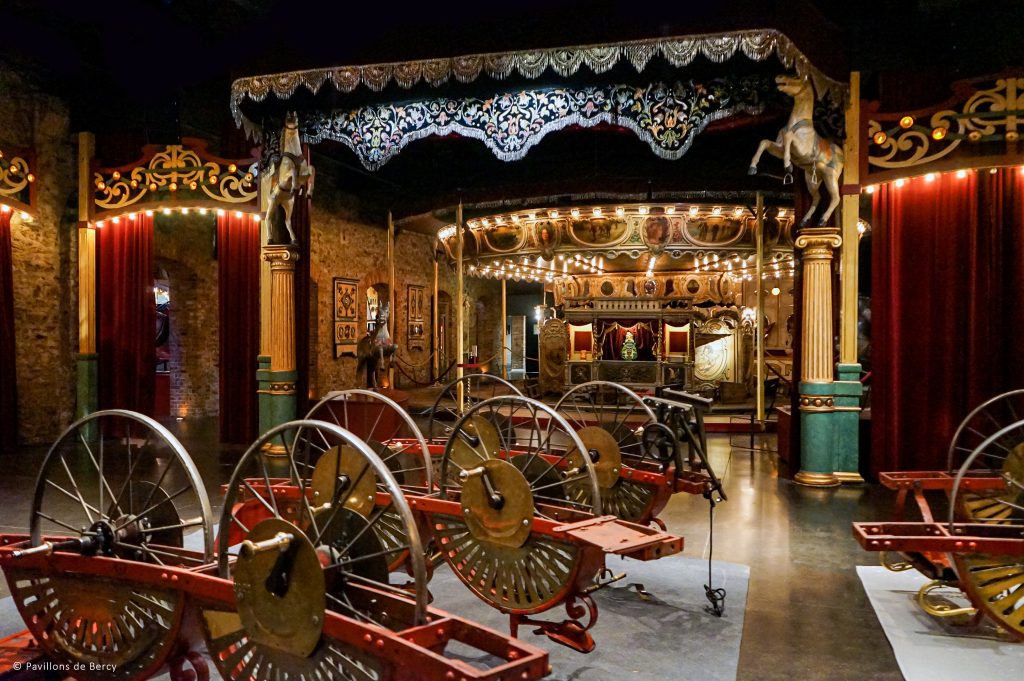 Paris en Février : Le Mois Secret des Amoureux et des Flâneurs. 1 Carrousel avec chariots en arrière-plan Musée des arts forains Paris